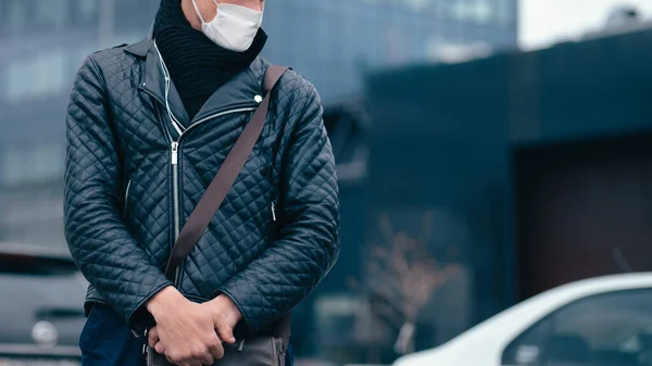 Junger Mann mit Schutzmaske steht auf der Straße — Stockfoto