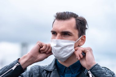 Kapat. Genç adam koruyucu bir maske takıyor.