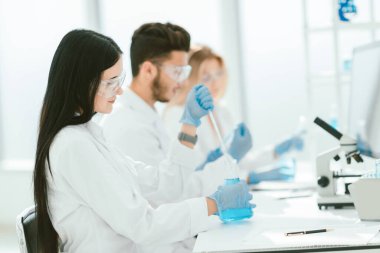 Kapat. Modern kadın iş arkadaşlarıyla laboratuarda oturuyor.