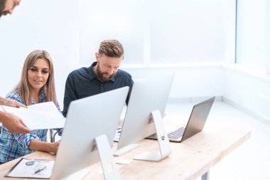 İş adamları çalışma belgelerini hafif bir ofiste tartışıyor..