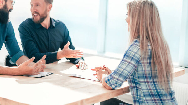 молодая женщина сидит на интервью в офисе.