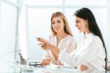 İki çalışan ofiste oturmuş bir şey tartışıyorlar.