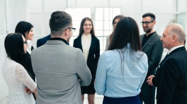 group of inspired young people stand and discuss a new project