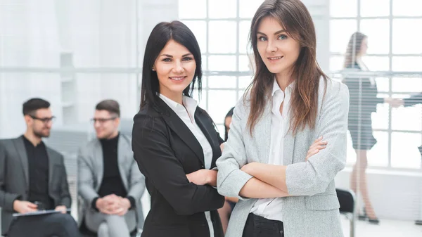 Dos jóvenes empresarias de pie en el cargo — Foto de Stock