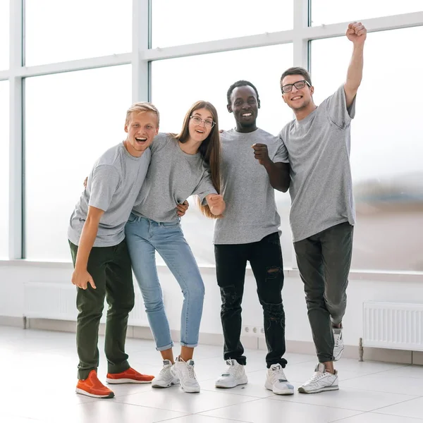 Jóvenes empleados felices de pie en una nueva oficina. — Foto de Stock