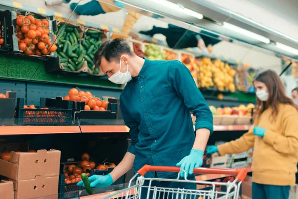 Acheteurs en masques protecteurs choisissant des fruits au supermarché — Photo