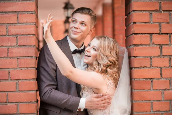 Happy newlywed couple hugging each other while walking — Stock Photo, Image