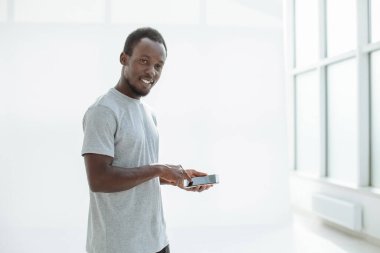 Yan görünüş. Şık genç adam akıllı telefonunu kullanıyor..