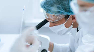 Kapat. Bir bilim adamının elinde yeni bir aşı olan ampul..