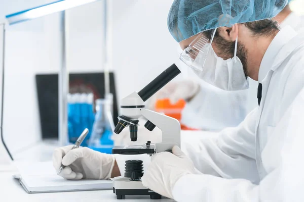 Assistente de laboratório realiza análise de testes em laboratório. — Fotografia de Stock