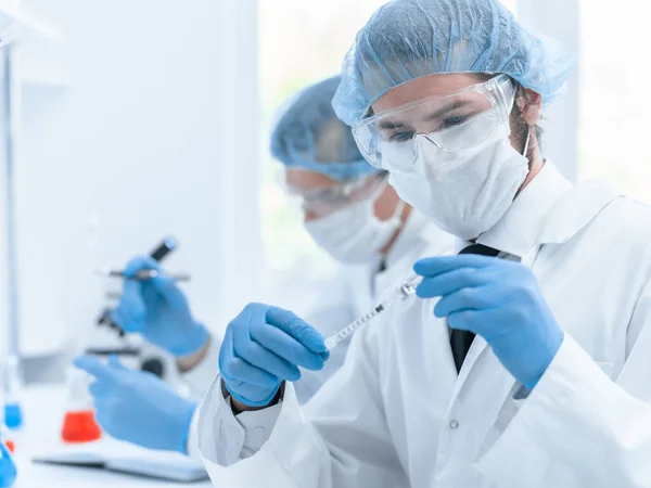 Fecha. grupo de cientistas em vestuário de protecção que trabalham no laboratório. — Fotografia de Stock