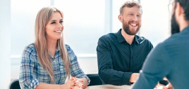 Yöneticiler ofis masasında oturan başvuru sahibi ile röportaj yaparlar..