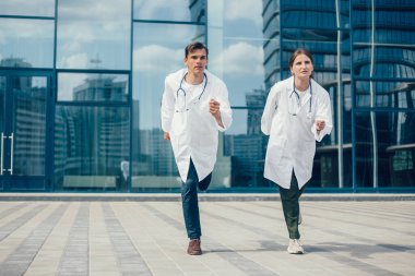 Sağlık görevlileri acil bir çağrı için şehir caddesinde koşuyorlar..