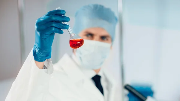 Vicino. fiaschetta medica nelle mani di un assistente di laboratorio. — Foto Stock