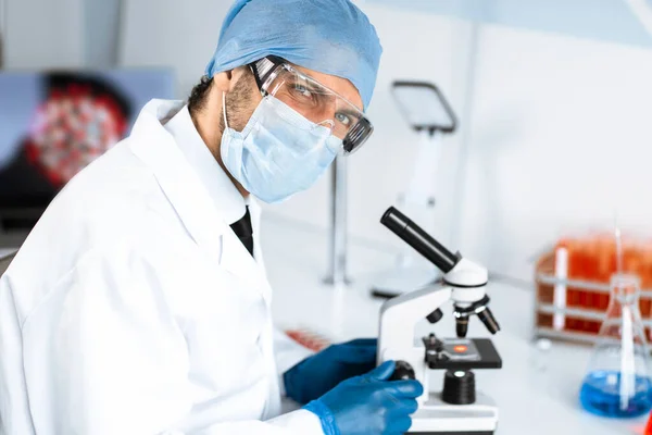 Cientista talentoso sentado a uma mesa no laboratório. — Fotografia de Stock