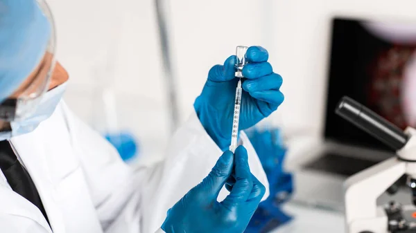 Fecha. cientista enchendo uma seringa com uma nova vacina. — Fotografia de Stock