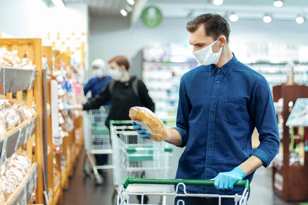 De près. jeune homme achetant du pain dans un supermarché. — Photo