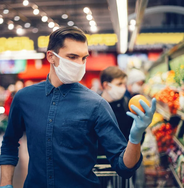 Client dans des gants de protection choisir des fruits dans un supermarché — Photo