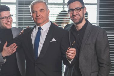 Patron ve mutlu iş ekibi ofis lobisinde bekliyor.