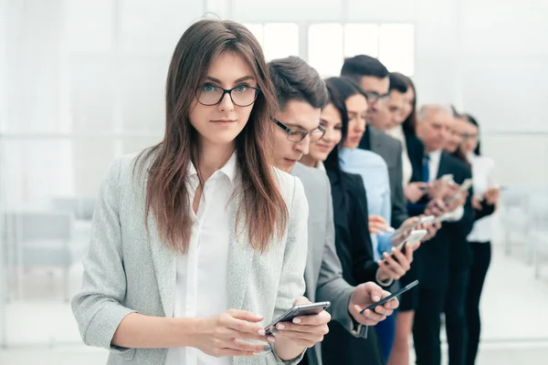 Grupo de pessoas de negócios com smartphones em pé em uma linha — Fotografia de Stock