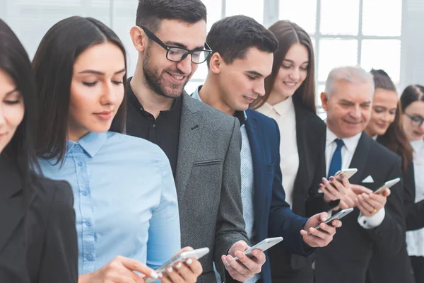 Grupo de pessoas de negócios com smartphones em pé em uma linha — Fotografia de Stock