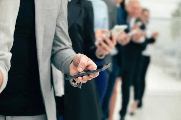 Groep van diverse medewerkers met smartphones op een rij — Stockfoto