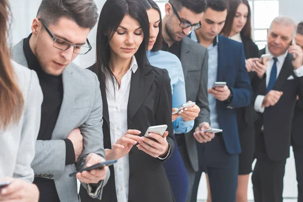 Akıllı telefonlarından mesaj okuyan bir grup genç.