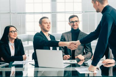 Finansal ortaklar bir ofis toplantısında birbirlerini selamlıyorlar.