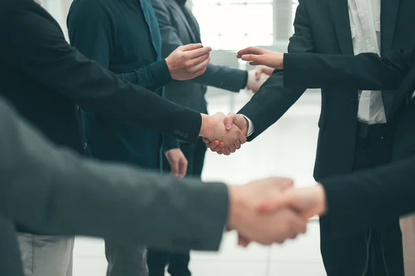 Nahaufnahme. Eine Gruppe junger Unternehmer schüttelt einander die Hand — Stockfoto