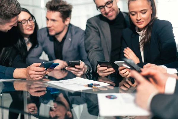 Grupo de funcionários usando seus smartphones no local de trabalho — Fotografia de Stock