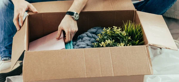 Pareja abriendo una caja de cartón con pertenencias personales . — Foto de Stock