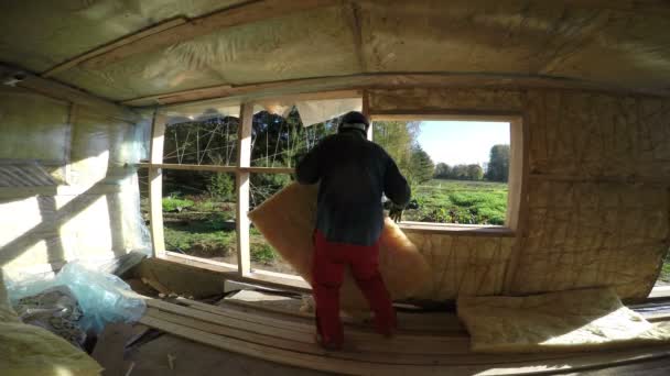 Builder insulating wooden house frame, 4K — Stock Video