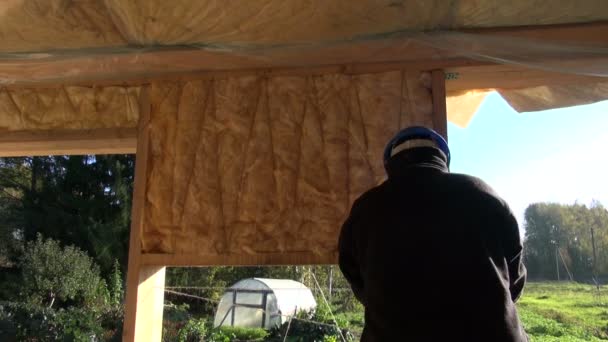 Constructeur portant un casque bleu isolant mur de la maison — Video