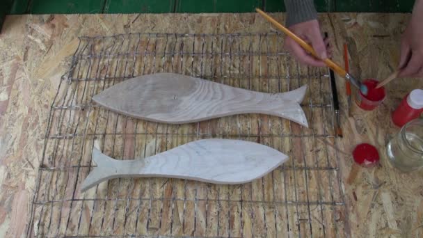 Artesano pintando peces de madera — Vídeos de Stock