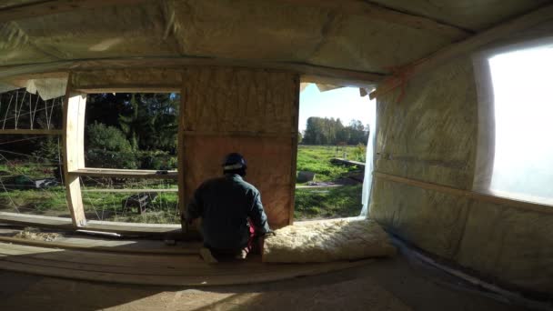 Builder with blue safety hat insulating house, 4K — Stock Video