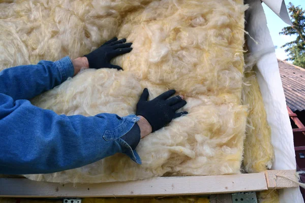 Builder hands insulating wooden house with mineral  wool — Stock Photo, Image