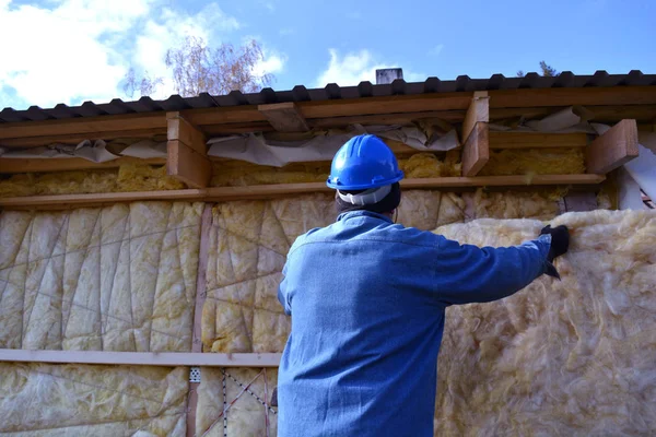 Εργαζόμενος με προστατευτικό καπέλο μόνωση τοίχου ξύλινο σπίτι — Φωτογραφία Αρχείου