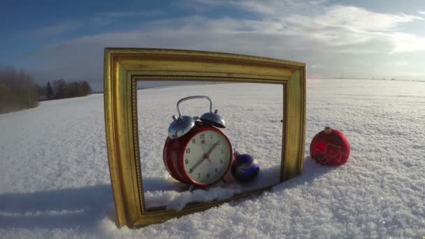 Gouden art-frame op veld sneeuw, Kerstbal en klok, time-lapse 4k — Stockvideo