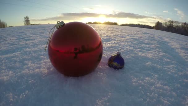 Bola de Navidad en el campo de diciembre nevado y la luz del atardecer, lapso de tiempo 4K — Vídeos de Stock