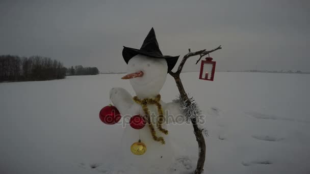 Nuevo año divertido muñeco de nieve con sombrero y lámpara de vela decorativa, 4K — Vídeo de stock