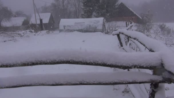 Queda de neve em cerca quebrada de madeira na antiga fazenda abandonada — Vídeo de Stock