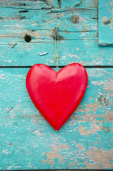 Coração vermelho pendurar no fundo da parede de madeira verde velho — Fotografia de Stock