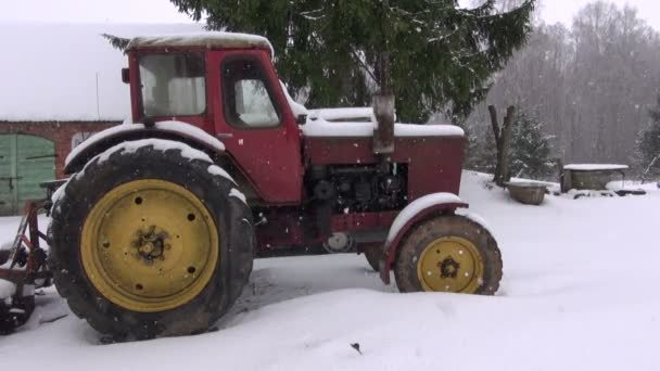 Velho trator soviético na fazenda na neve e inverno nevasca — Vídeo de Stock