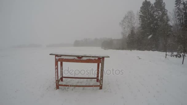 Snöstorm snöfall på gården yard och röda gamla träbord, tidsinställd 4k — Stockvideo