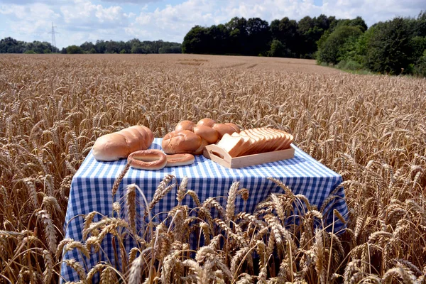 Bílý chléb na stůl v zralé pšeničné pole — Stock fotografie