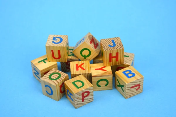 Alfabetycznej drewniane kostki stosu na niebieskim tle — Zdjęcie stockowe