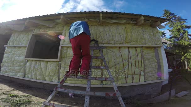 Trabajador aislante con material de lana de roca casa de madera pared — Vídeos de Stock