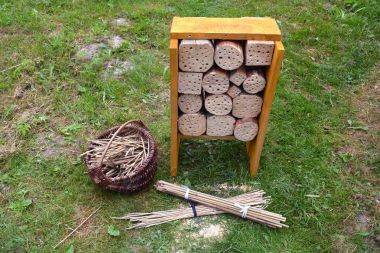 New Insect hotel  and reeds in basket in garden  clipart