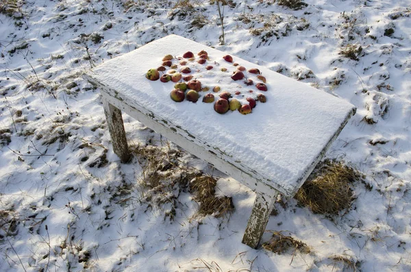 Manzanas al aire libre en la vieja mesa de madera en invierno nieve — Foto de Stock