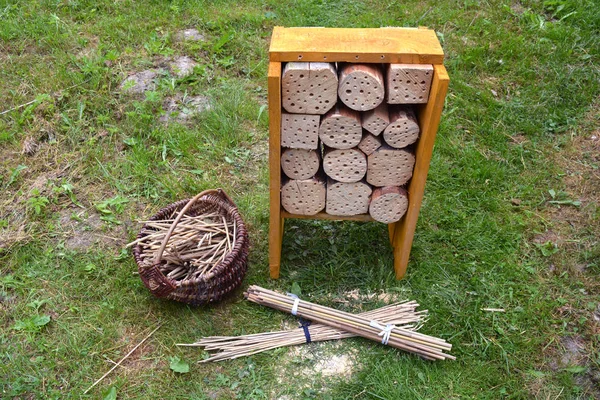New Insect hotel  and reeds in basket in garden — Stock Photo, Image